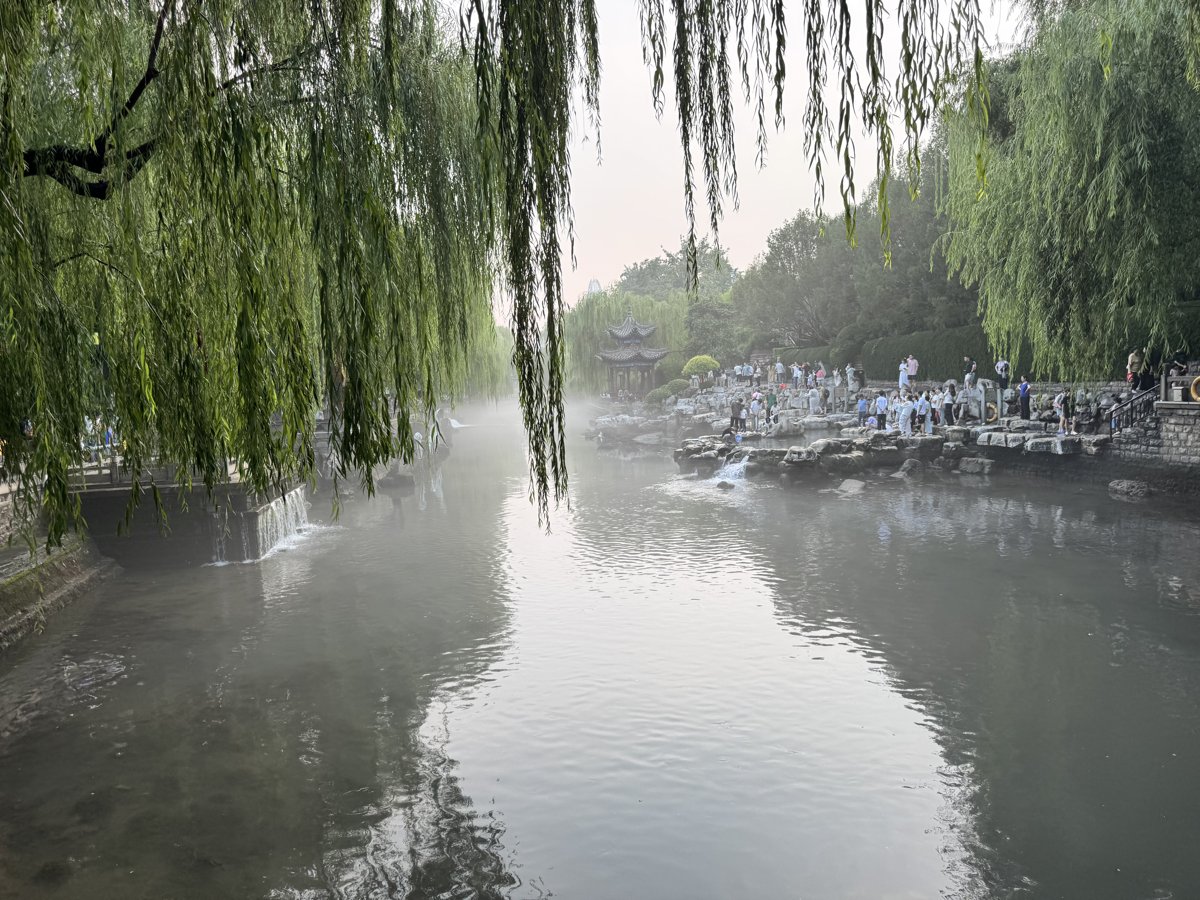The city moat near Black Tiger Spring: willows line the banks, and spring water pours in